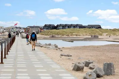 a group of people walking on a boardwalk on the beach at 1302-Thisted-Havstokken-30-1 in Thisted