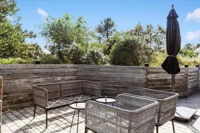 a patio with a table and an umbrella and chairs at 511-Thisted-Blabaervej-16 in Thisted