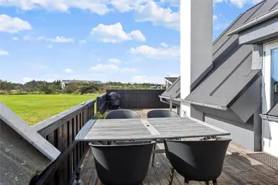 a wooden deck with a table and chairs on a house at 1007-Thisted-Mombak-7 in Torsted