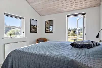 a white bedroom with a bed and two windows at 332-Thisted-Kristinesvej-32 in Thisted
