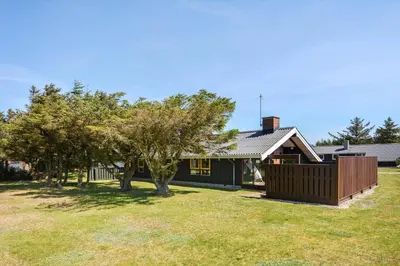 a house with a fence and trees in a yard at 829-Thisted-Nordsovej-188 in Thisted
