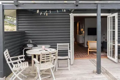 a patio with a table and chairs on a deck at 930-Thisted-Liusborg-Sti-28 in Torsted