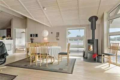 a dining room with a table and a fireplace at 858-Thisted-Delfinvej-24 in Thisted