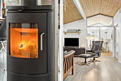 a fireplace in a living room with a desk at 118-Vestervig-Sivsangervej-18 in Vestervig