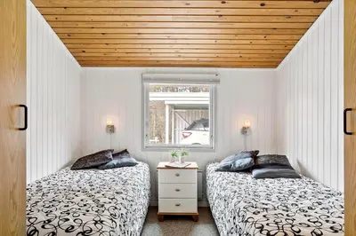 two beds in a small bedroom with a window at 118-Vestervig-Sivsangervej-18 in Vestervig