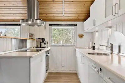 a kitchen with white appliances and a wooden ceiling at 118-Vestervig-Sivsangervej-18 in Vestervig