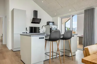 a kitchen with two black chairs at a counter at 1300-Thisted-Smedevej-3-B in Thisted