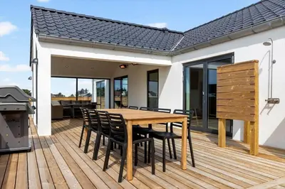 a wooden table and chairs on a deck with a grill at 1300-Thisted-Smedevej-3-B in Thisted