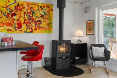 a living room with a fireplace and red chairs at 420-Vestervig-Kanalvej-4 in Vestervig