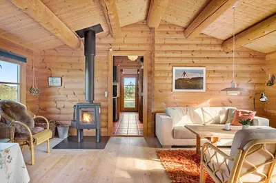 a living room with a fireplace in a log cabin at 651-Snedsted-Somaerkevej-50 in Snedsted