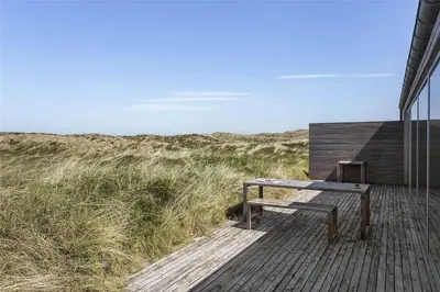 a wooden deck with a bench on the beach at 768-Snedsted-Somaerkevej-68 in Snedsted
