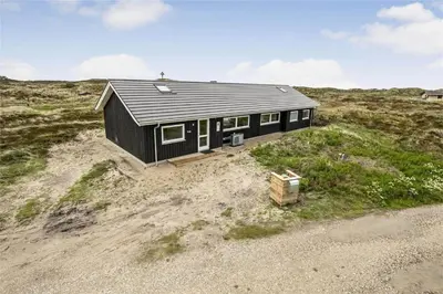 a black house sitting on top of a beach at 899-Snedsted-Somaerkevej-76-B in Snedsted