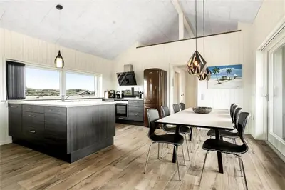 a kitchen with a table and chairs and a sink at 899-Snedsted-Somaerkevej-76-B in Snedsted