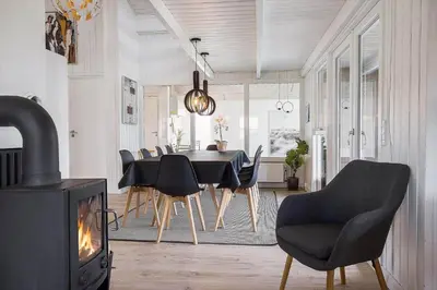 a dining room with a fireplace and a table and chairs at 446-Thisted-Nordsovej-206-F in Thisted