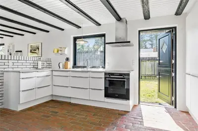 a kitchen with white cabinets and a black oven at 142-Thisted-Pighvarvej-4 in Thisted