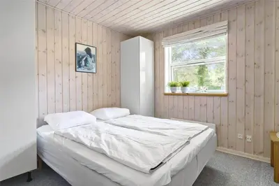 a bedroom with a large bed with a window at 879-Thisted-Pighvarvej-3 in Thisted