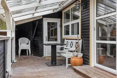 a porch with a table and chairs on a house at 873-Thisted-Blamunkevej-67 in Thisted