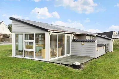 a small white house with a deck in a yard at 276-Thisted-Nordsovej-76 in Thisted
