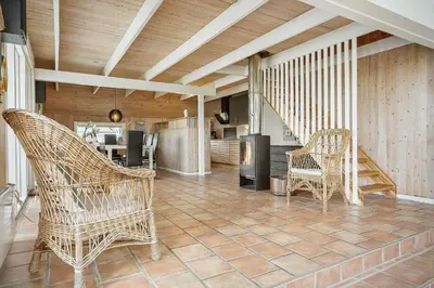 a living room with two chairs and a kitchen at 186-Vestervig-Magevej-5 in Vestervig