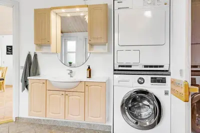 a bathroom with a sink and a washing machine at 1050-Thisted-Spanggardsvej-5 in Torsted