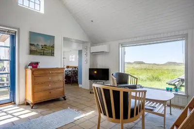 a living room with a table and a television at 957-Thisted-Hvidbakken-33-Lille-hus in Torsted