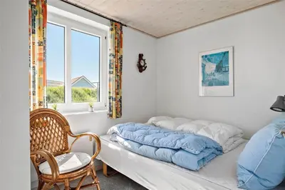 a bed in a room with a window and a chair at 451-Thisted-Nordsovej-20 in Thisted