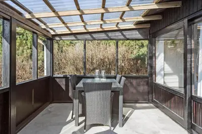 a screened in porch with a table and chairs at 828-Thisted-Orredvej-13 in Thisted