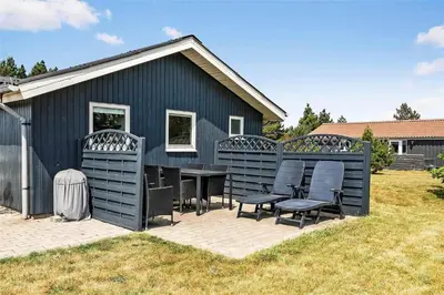 a blue house with chairs and a table in the yard at 770-Thisted-Nordsovej-180 in Thisted