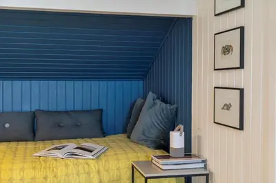 a bed with a blue headboard and a table with a book at 904-Thisted-P-Bolesens-Vej-15 in Torsted