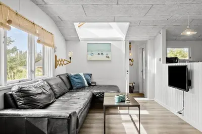 a living room with a leather couch and a tv at 1308-Thisted-Tunvej-12 in Thisted