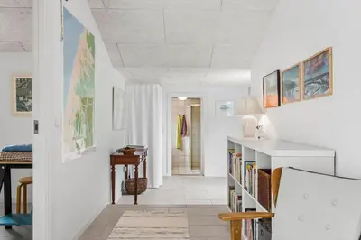 a hallway with white walls and a staircase with a book shelf at 459-Snedsted-Istrupvej-48 in Snedsted
