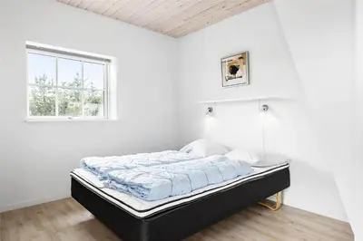 a bed in a white room with a window at 222-Thisted-Nordsovej-57 in Thisted