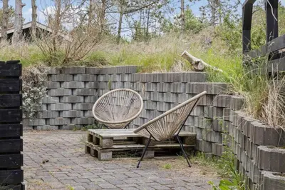 two chairs and a bench next to a brick wall at 458-Thisted-Sandtornvej-18 in Thisted