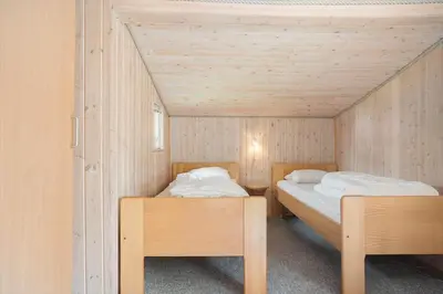 two beds in a room with wooden walls at 619-Thisted-Blabaervej-32 in Thisted