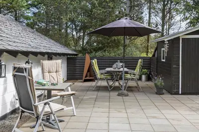 a patio with an umbrella and a table and chairs at 834-Thisted-Revlingvej-9 in Thisted