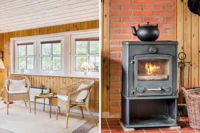 a fireplace in a living room with a table and a room with a stove at 861-Thisted-Havbovej-41 in Thisted