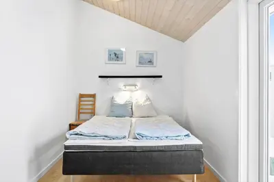 a bed in a room with a white wall at 599-Thisted-Fiskervej-165 in Thisted