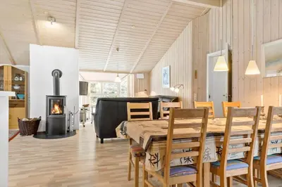 a dining room with a table and chairs and a fireplace at 599-Thisted-Fiskervej-165 in Thisted