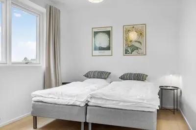 a white bed in a white bedroom with a window at 1305-Snedsted-Klitfogedvej-5 in Snedsted