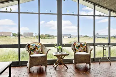 a screened in porch with two chairs and a table at 928-Thisted-Kobbelsti-15 in Torsted