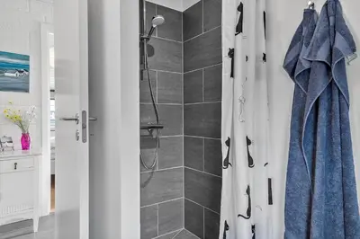 a bathroom with a shower with a blue shower curtain at 447-Thisted-Kuttervej-13 in Thisted