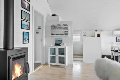 a living room with a fireplace and a kitchen at 447-Thisted-Kuttervej-13 in Thisted