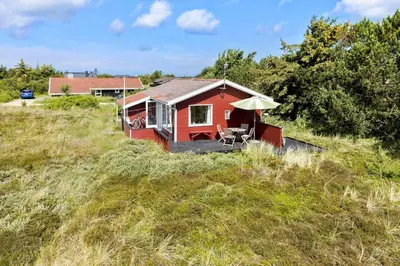 a red house with an umbrella on a hill at 240-Thisted-Hummervej-10 in Thisted