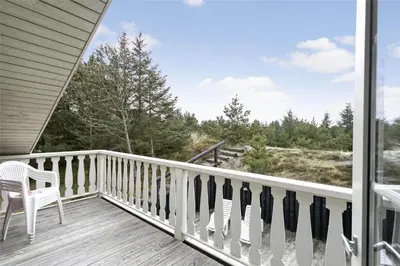 a porch with a chair and a view of the ocean at 929-Thisted-Brandisvej-19 in Torsted