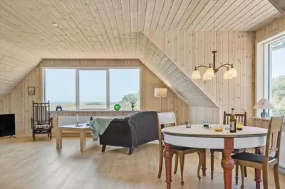 a living room with a table and chairs and a staircase at 1051-Thisted-Skjaerbakken-57 in Torsted