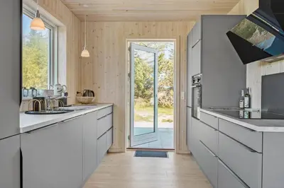 a kitchen with white cabinets and a large doorway at 1051-Thisted-Skjaerbakken-57 in Torsted