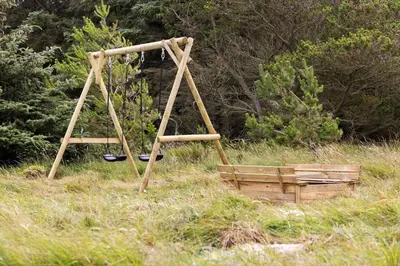 a wooden swing set in a field with trees at 479-Thisted-Kristinesvej-36 in Thisted
