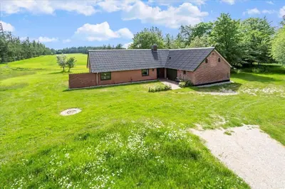 a small house on a grassy hill with a field at 591-Snedsted-Stenbjergvej-28 in Snedsted