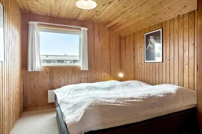 a bedroom with a bed in a wooden wall at 533-Thisted-Fiskervej-153 in Thisted