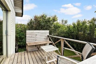 a wooden deck with a bench and two chairs on it at 204-Vestervig-Lodbjergvej-4 in Vestervig